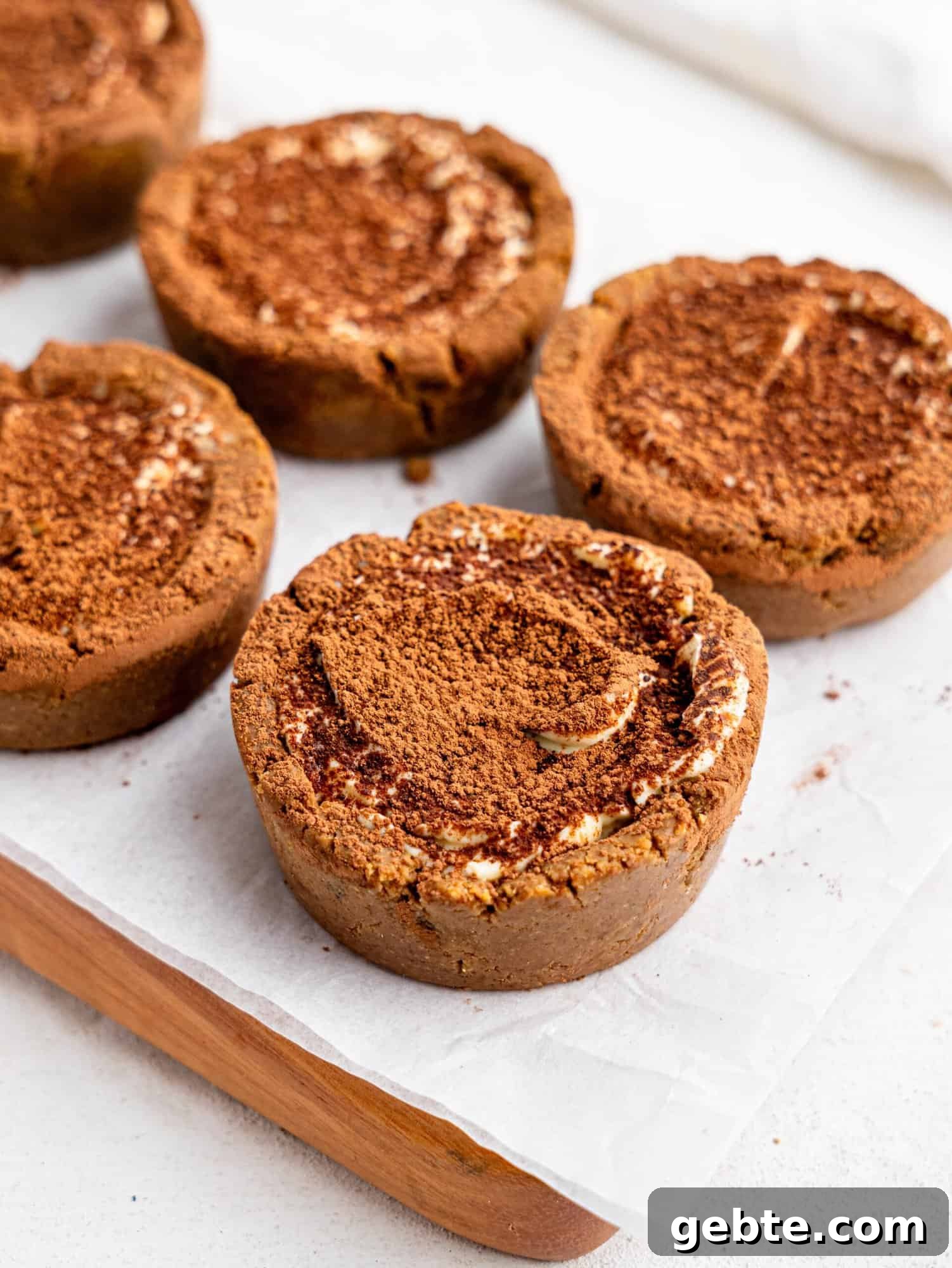 Tiramisu cookie dough cups on a wooden board.