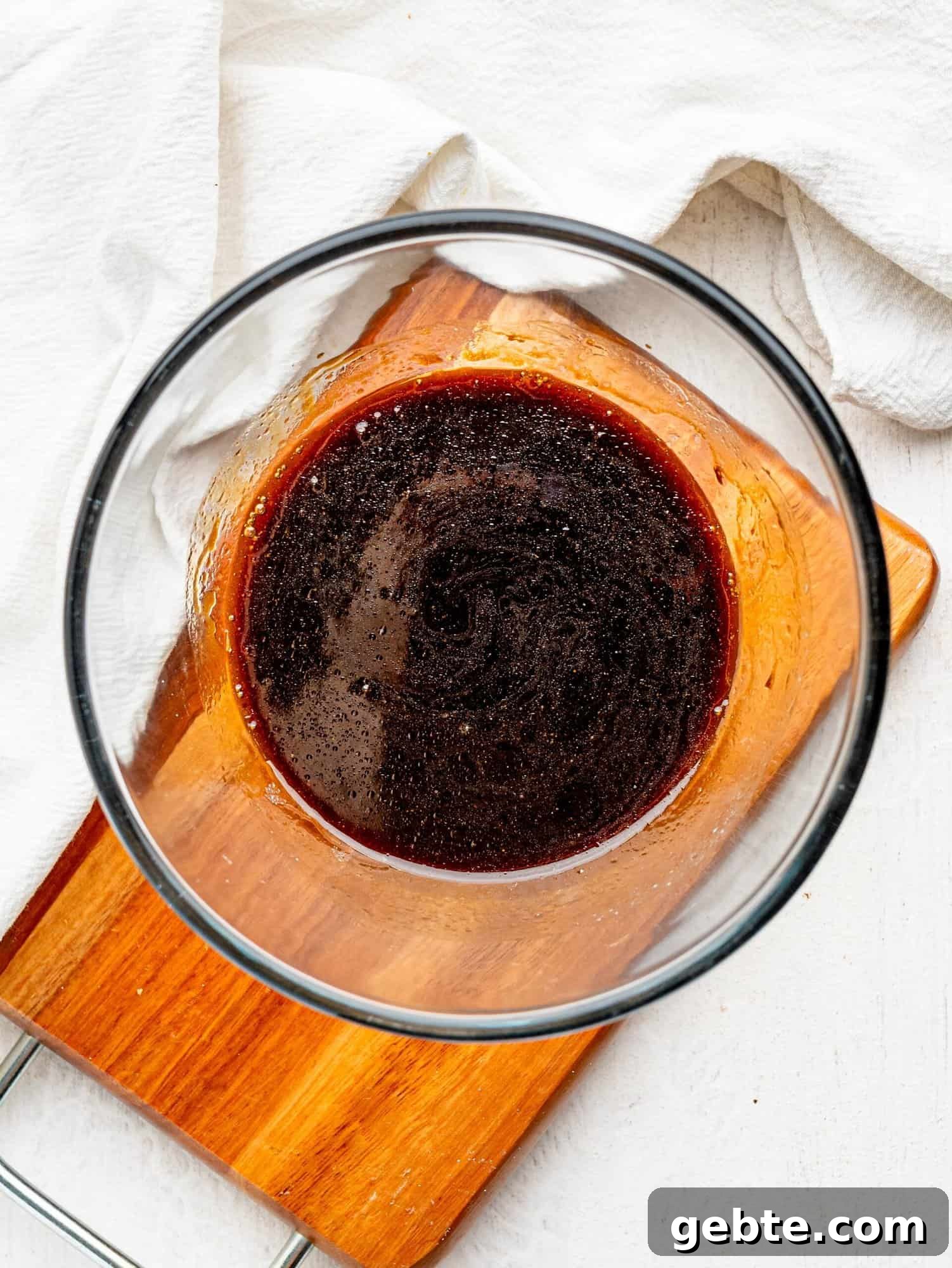 Melted butter, coffee and honey combined in a glass bowl.