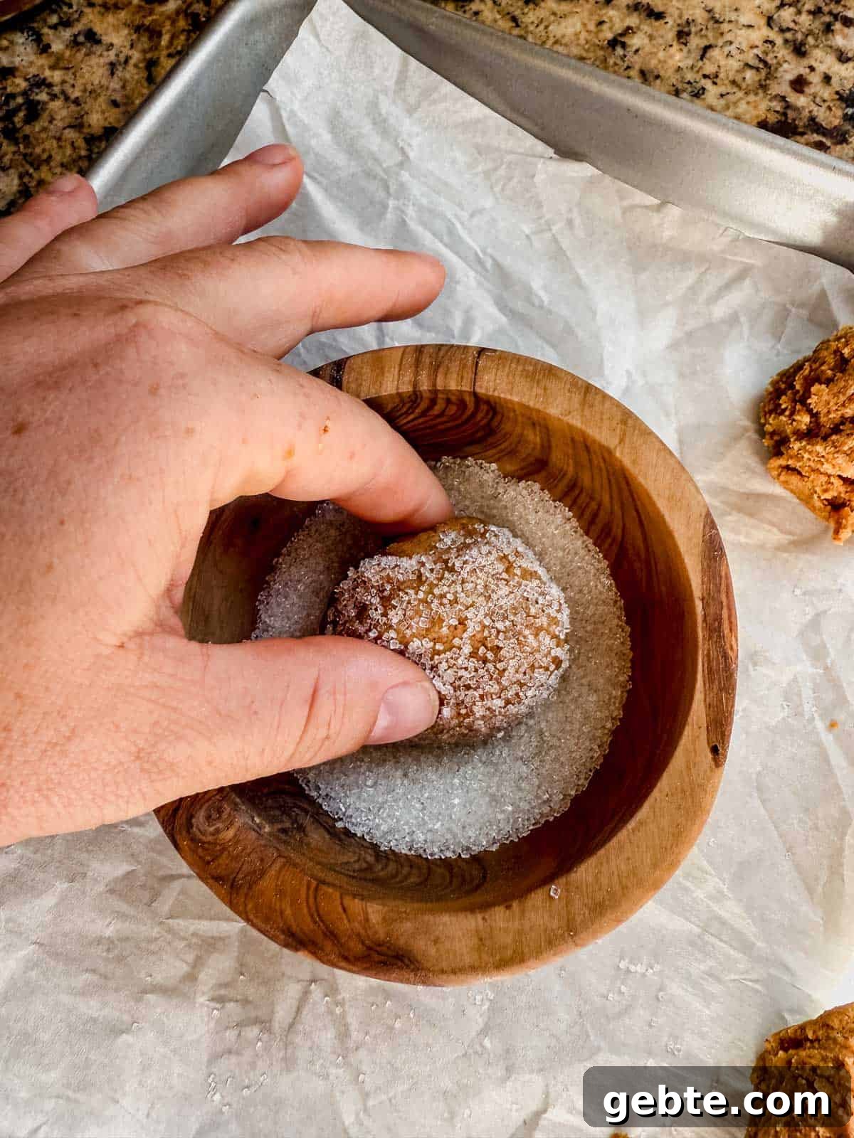 Gingerbread Latte Cookies Recipe — Cozy Spiced Coffee Cookies 7 rolling gingerbread latte cookie dough ball in a bowl of sugar.