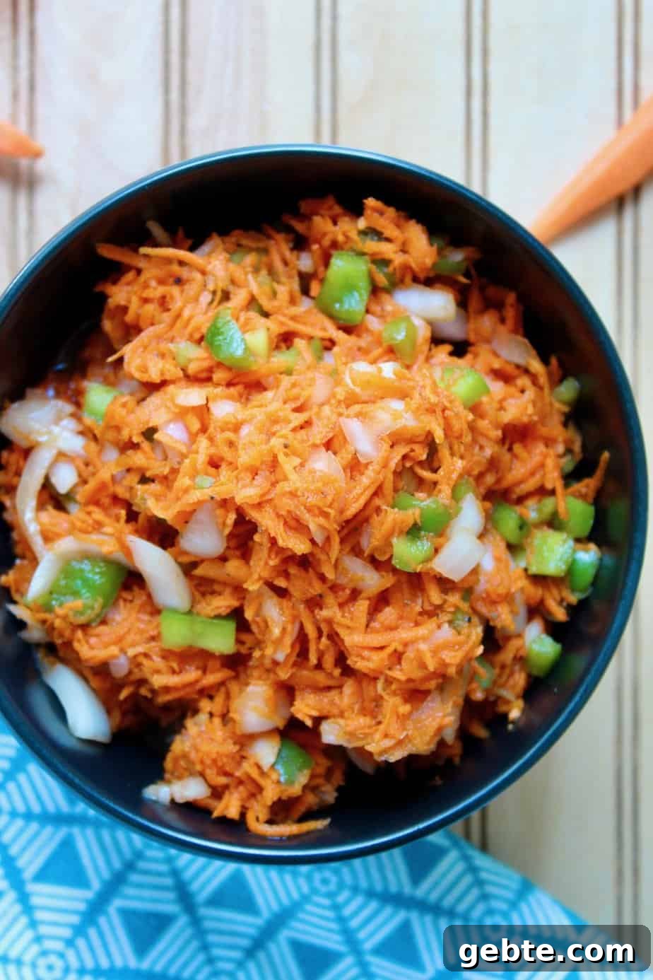 Carrot salad without mayonnaise in black serving bowl.