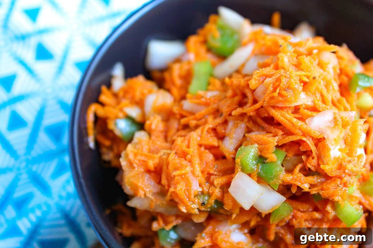 Carrot Slaw in black bowl with bell peppers and onion