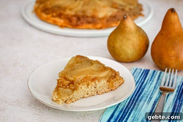 A slice of pear upside-down cake on a plate.
