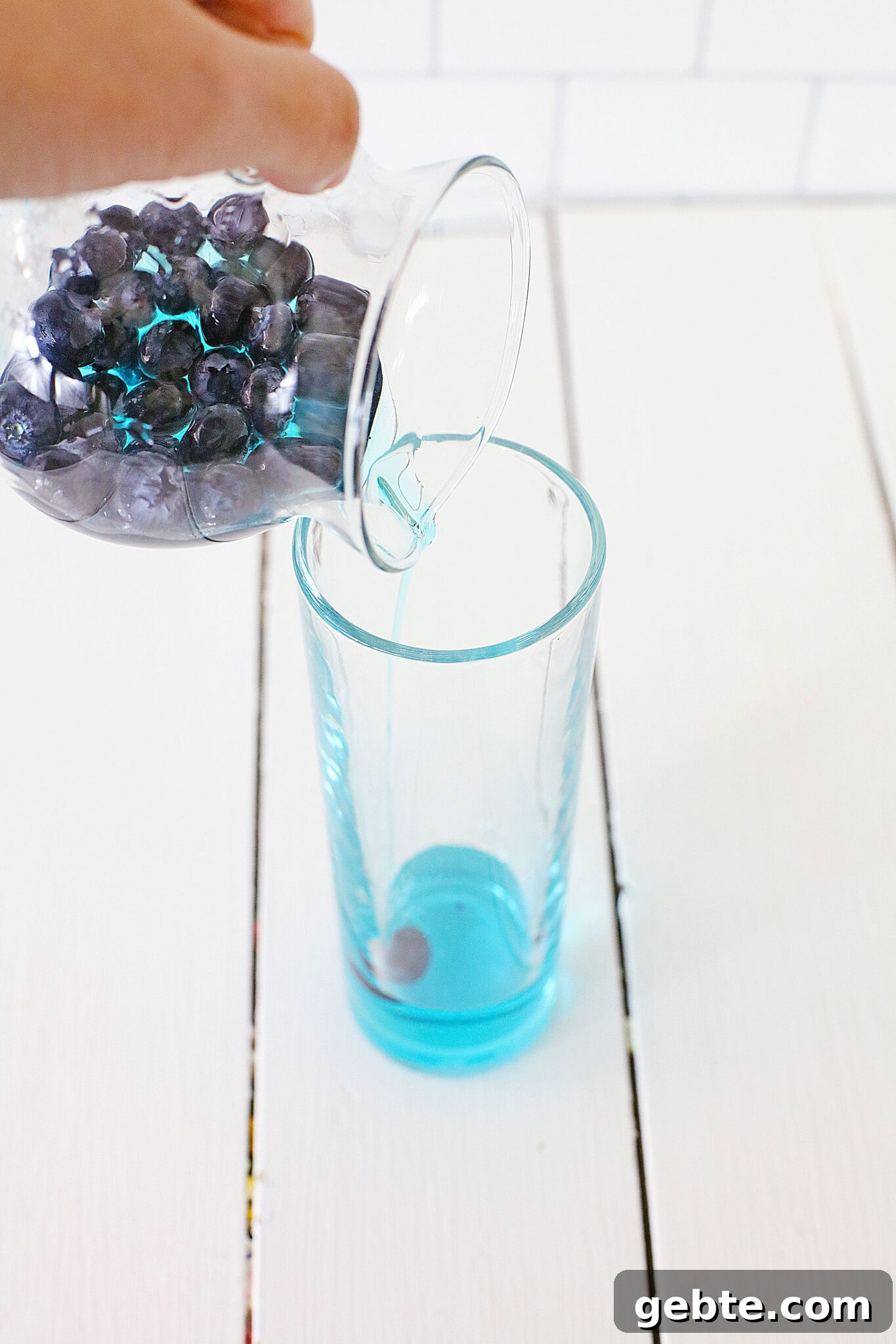 Blueberry Vodka Lemonade Recipe: Refreshing Summer Cocktail 7 Blueberries being poured into a glass