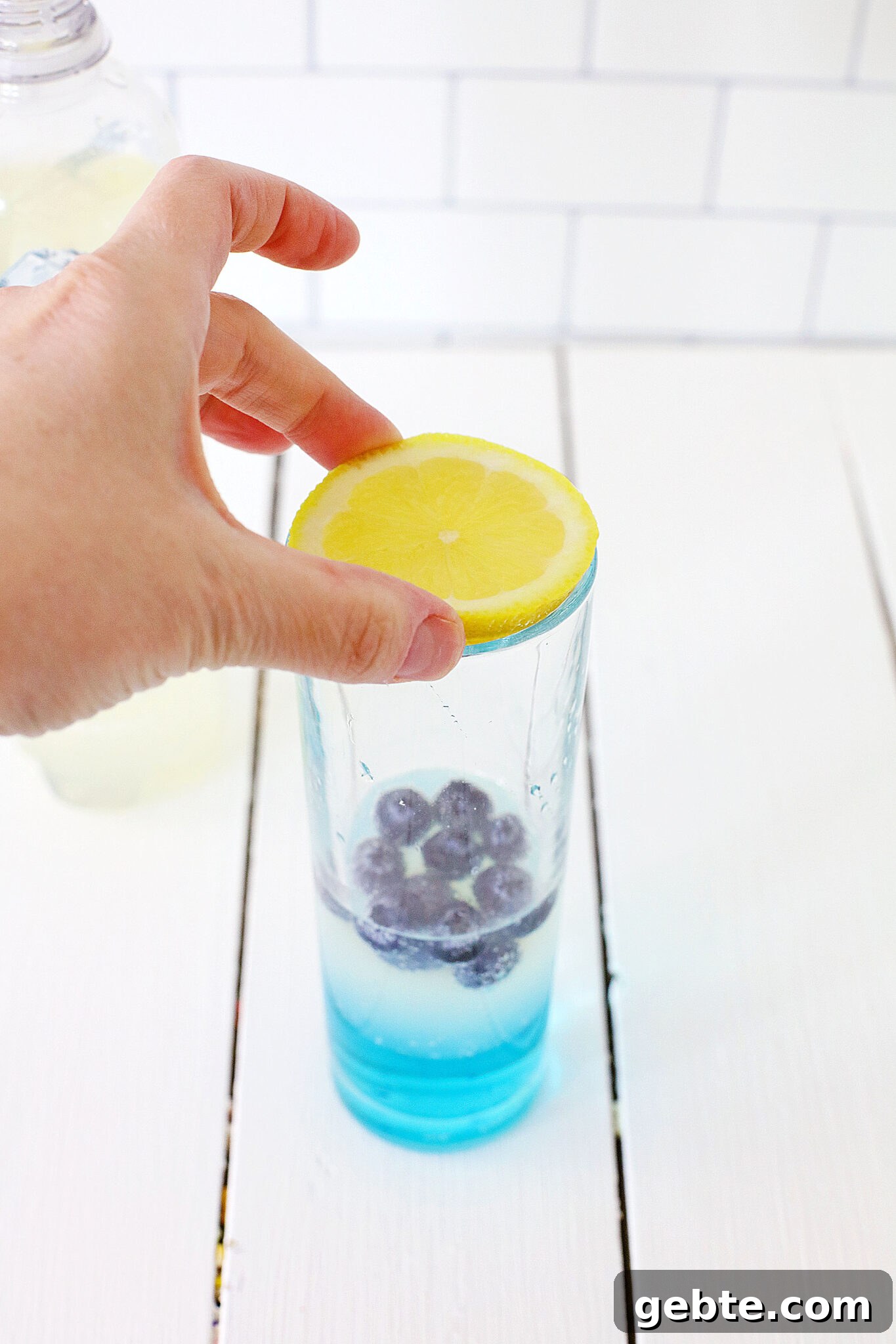 Blueberry Vodka Lemonade Recipe: Refreshing Summer Cocktail 10 Lemon slice being added to the glass
