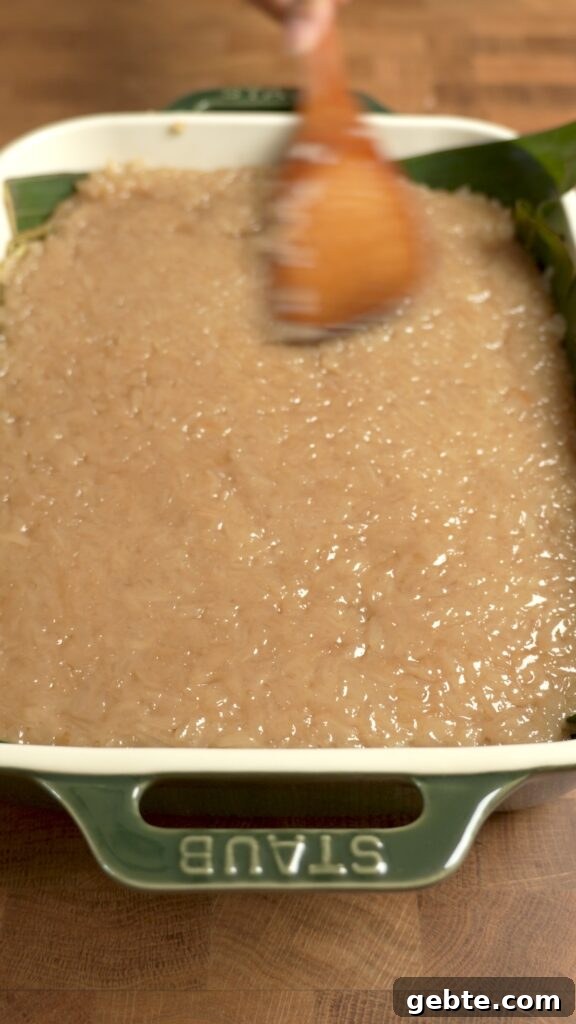Biko: Filipino Caramelized Sticky Rice Dessert Recipe 9 Spreading and flattening the biko in the baking dish.