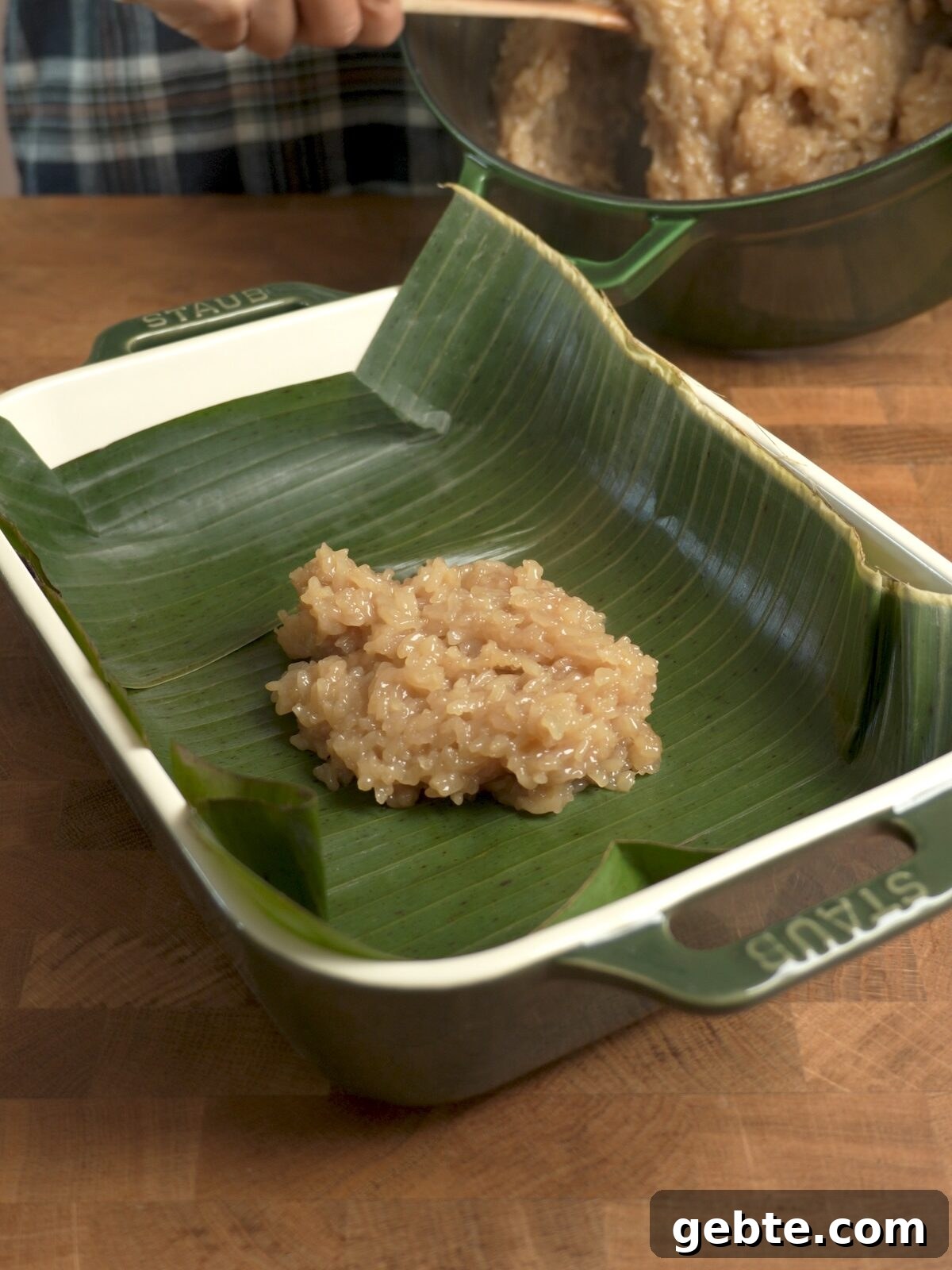 Biko: Filipino Caramelized Sticky Rice Dessert Recipe 4 Transferring hot, fresh biko into a pan lined with banana leaves