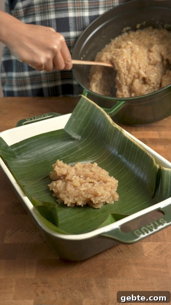Biko: Filipino Caramelized Sticky Rice Dessert Recipe 8 Transferring hot, fresh biko into a pan lined with banana leaves