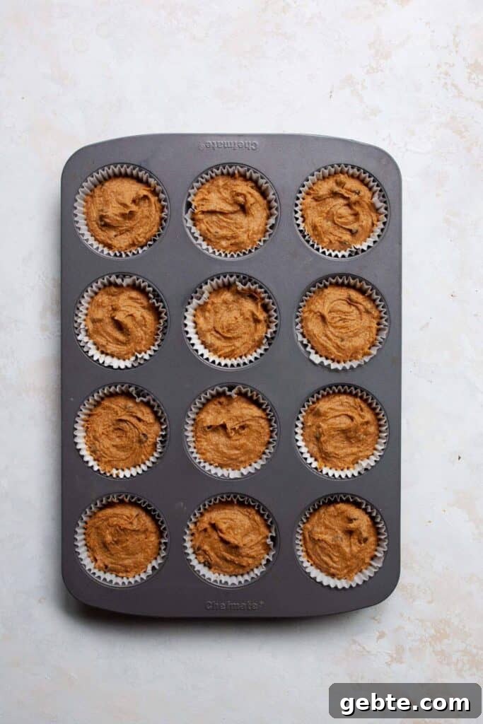 healthy pumpkin muffins batter in cupcake tin with liners before baking