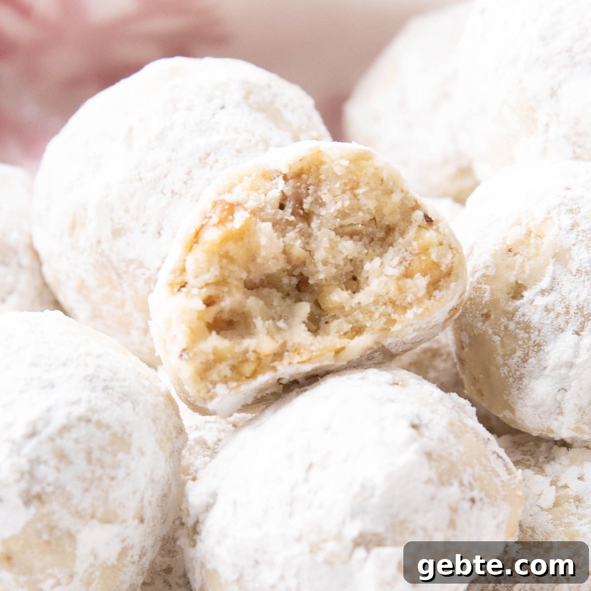 close up of a half bitten snowball cookie to show the tender texture