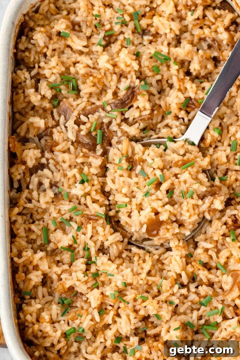 Stick of Butter Rice in a casserole dish with a large serving spoon.