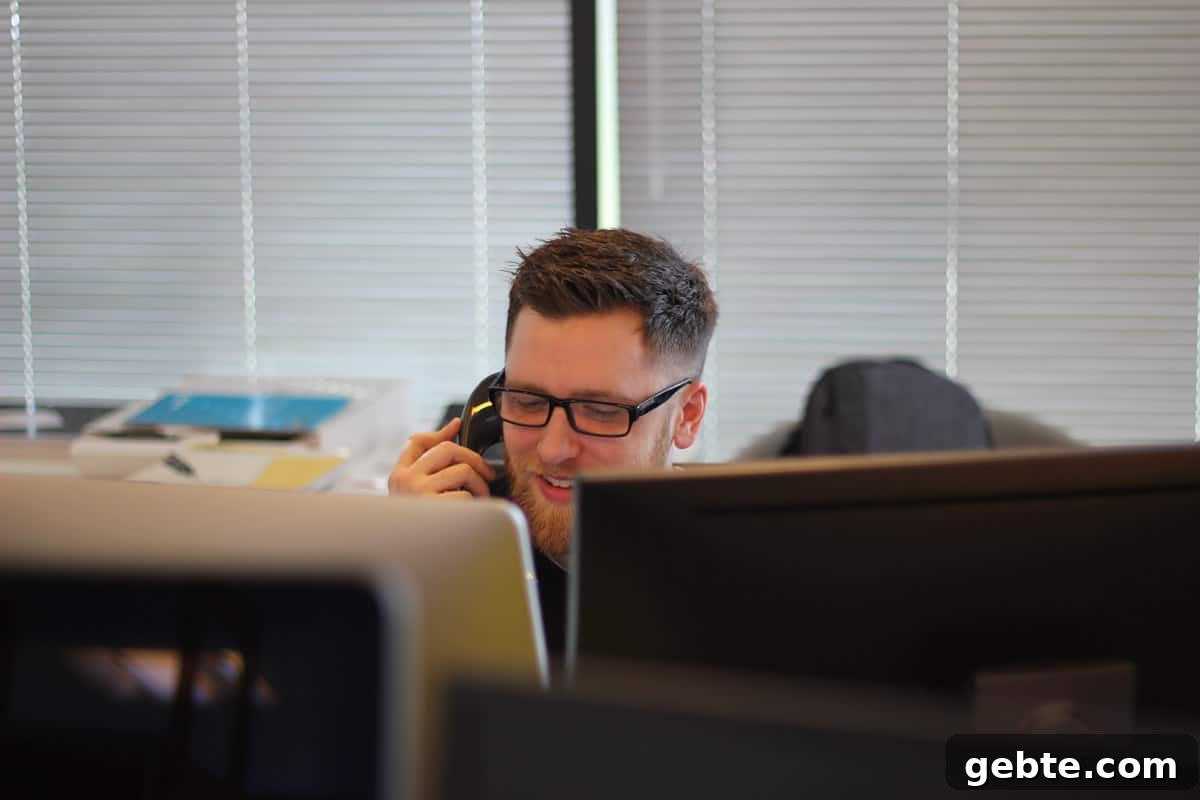Man on phone behind several computer monitors