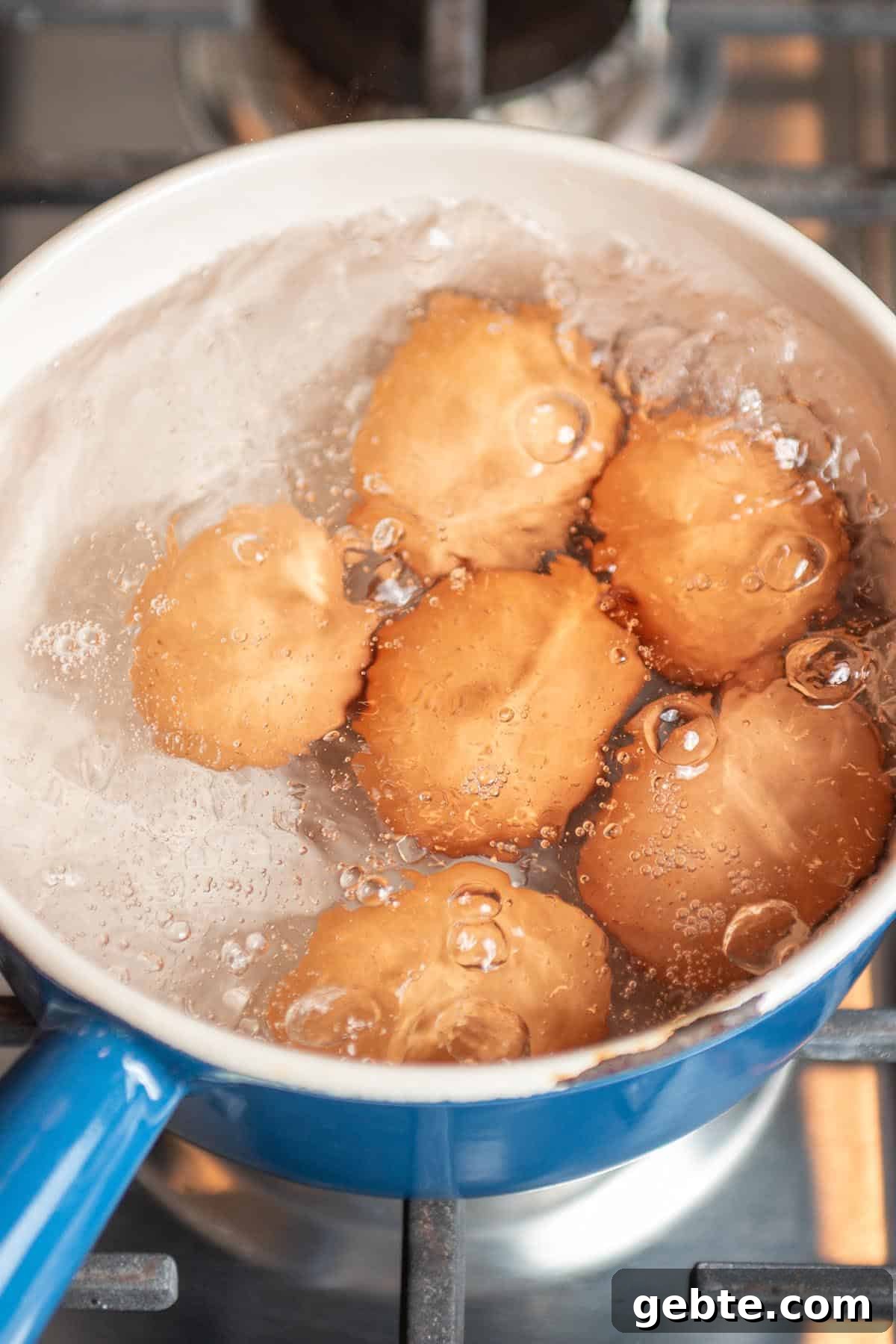 A small pot with brown eggs in boiling water.