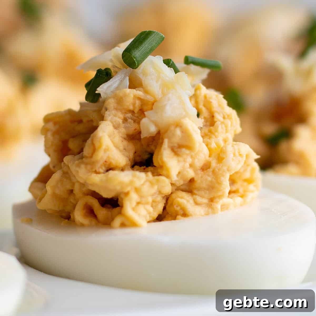 A deviled egg topped with fresh Dungeness crab and chive.