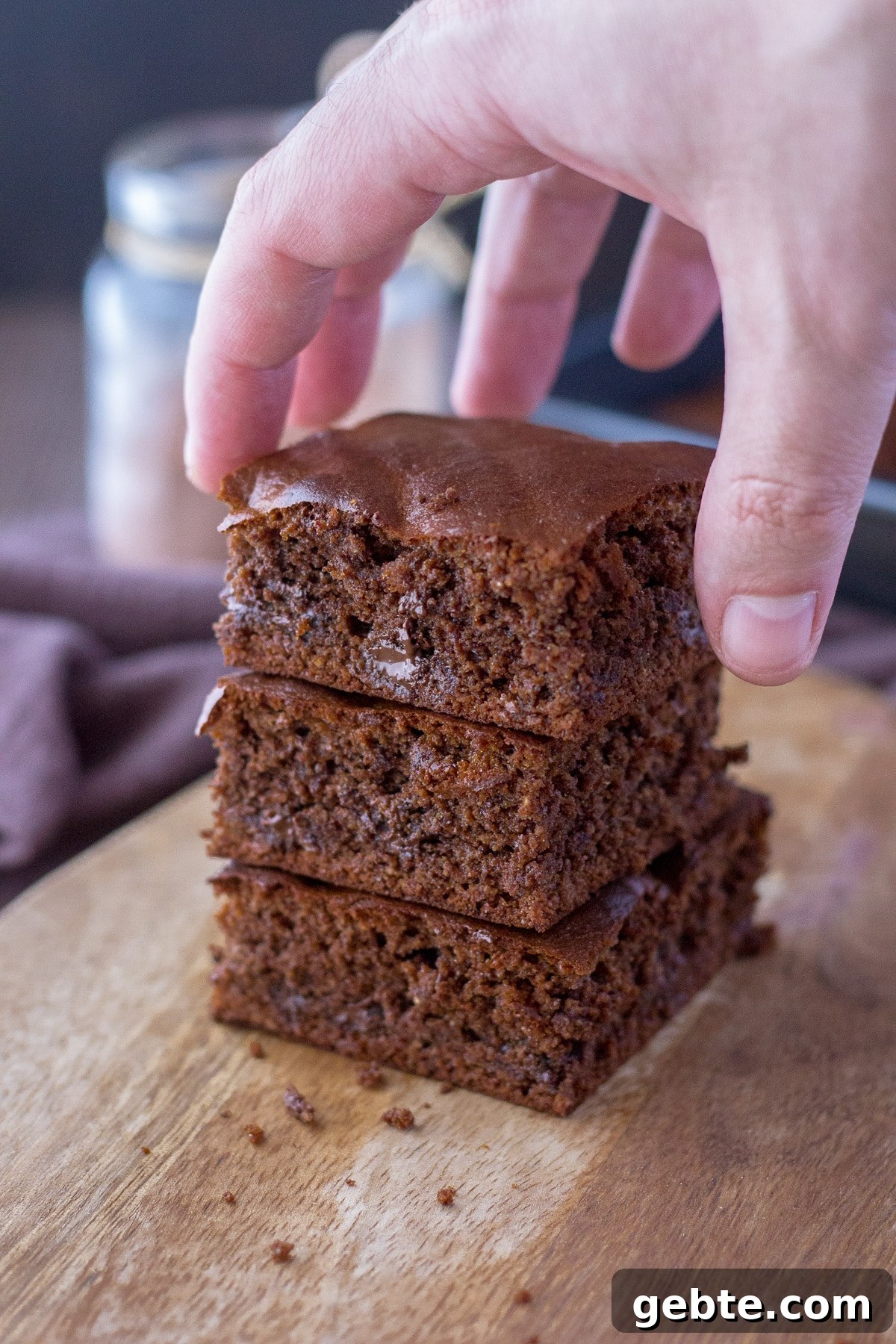 A hand taking the slice of almond butter brownies