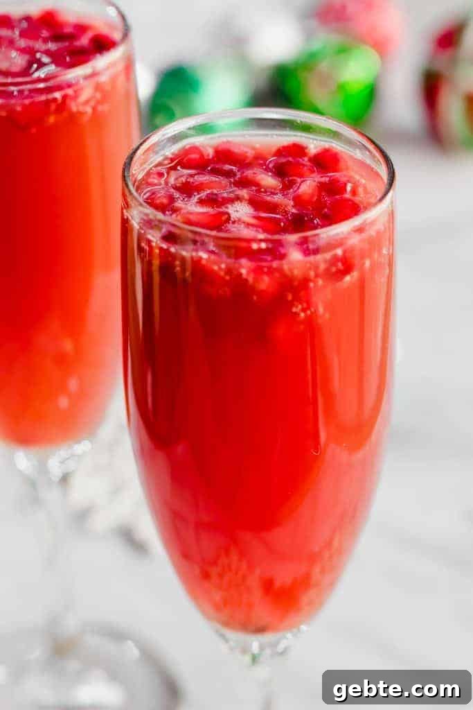Sparkling Christmas Mimosa Recipe: Festive Holiday Brunch Cocktail 3 Christmas Mimosas in a champagne flute with pomegranate arils