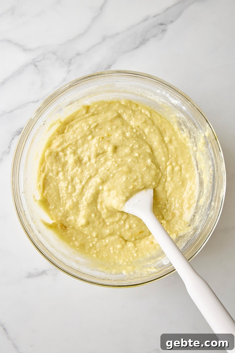 Mixed batter in glass bowl with spatula