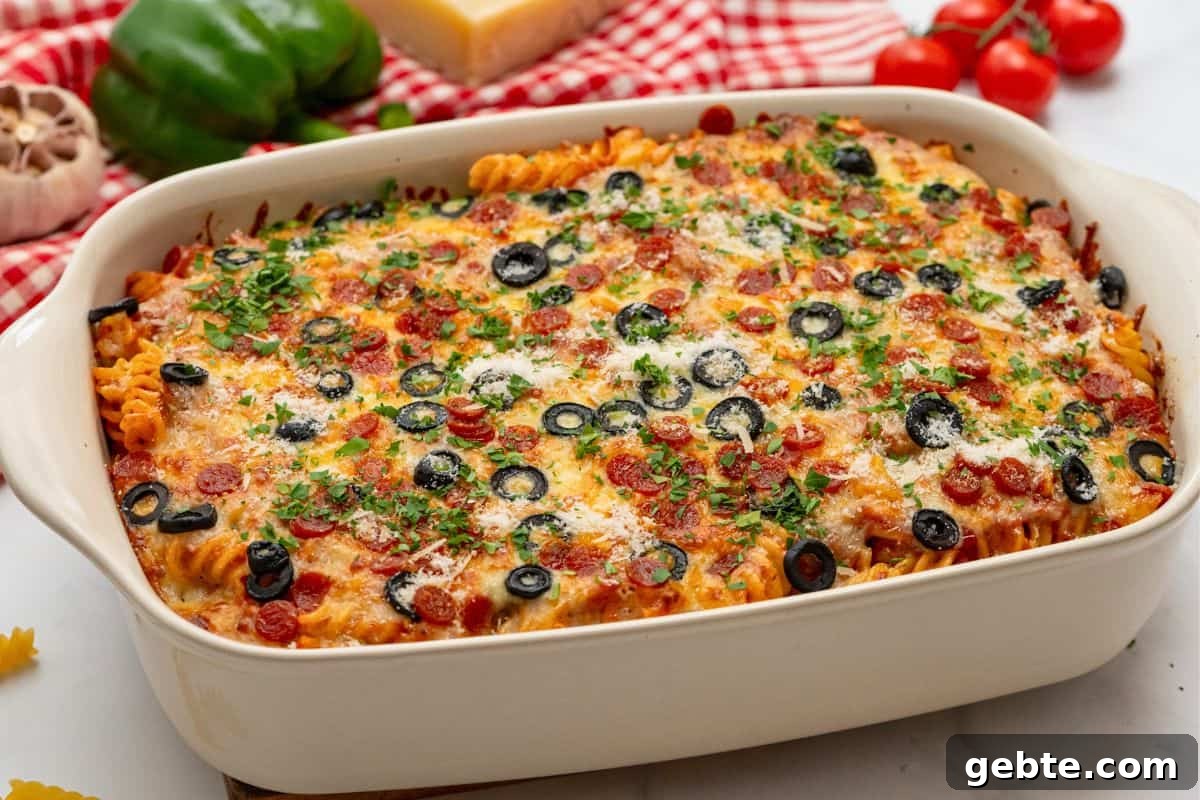 Pasta bake topped with pizza sauce, cheese, olives, and pepperoni in casserole dish baked until cheese is golden.