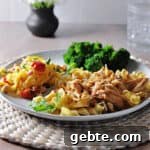 Instant pot french onion chicken with noodles on a plate with broccoli and a salad