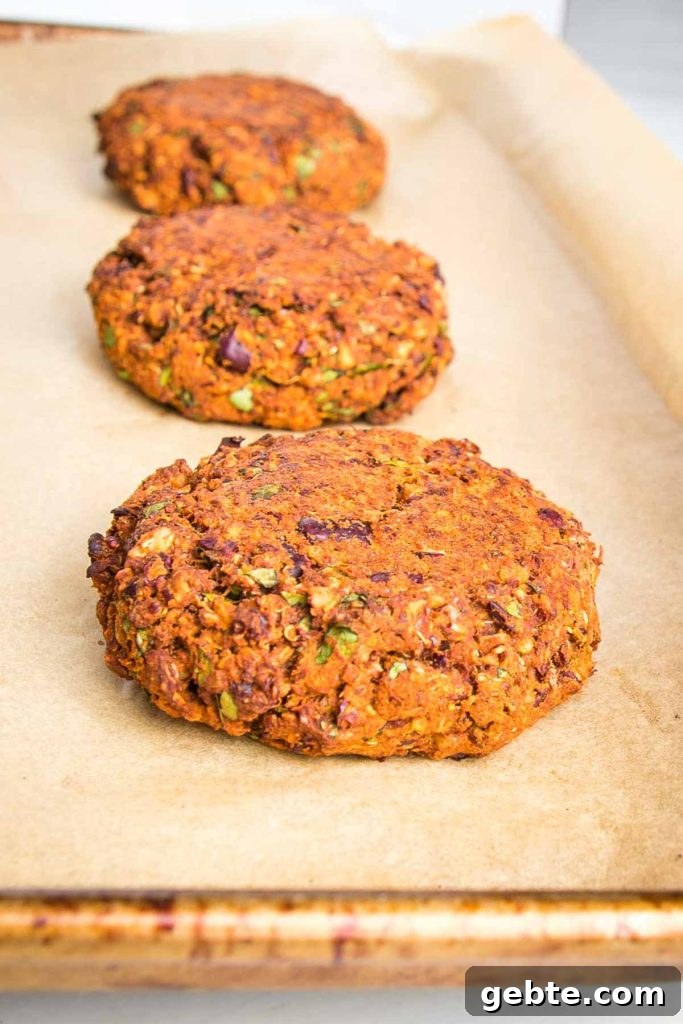 Veggie burger patties on a parchment lined baking sheet.