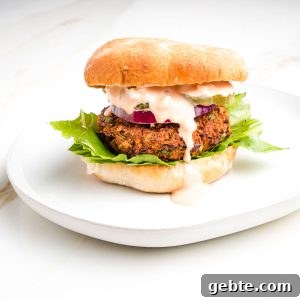 Veggie burger in a bun with lettuce and sauce dripping down the side.