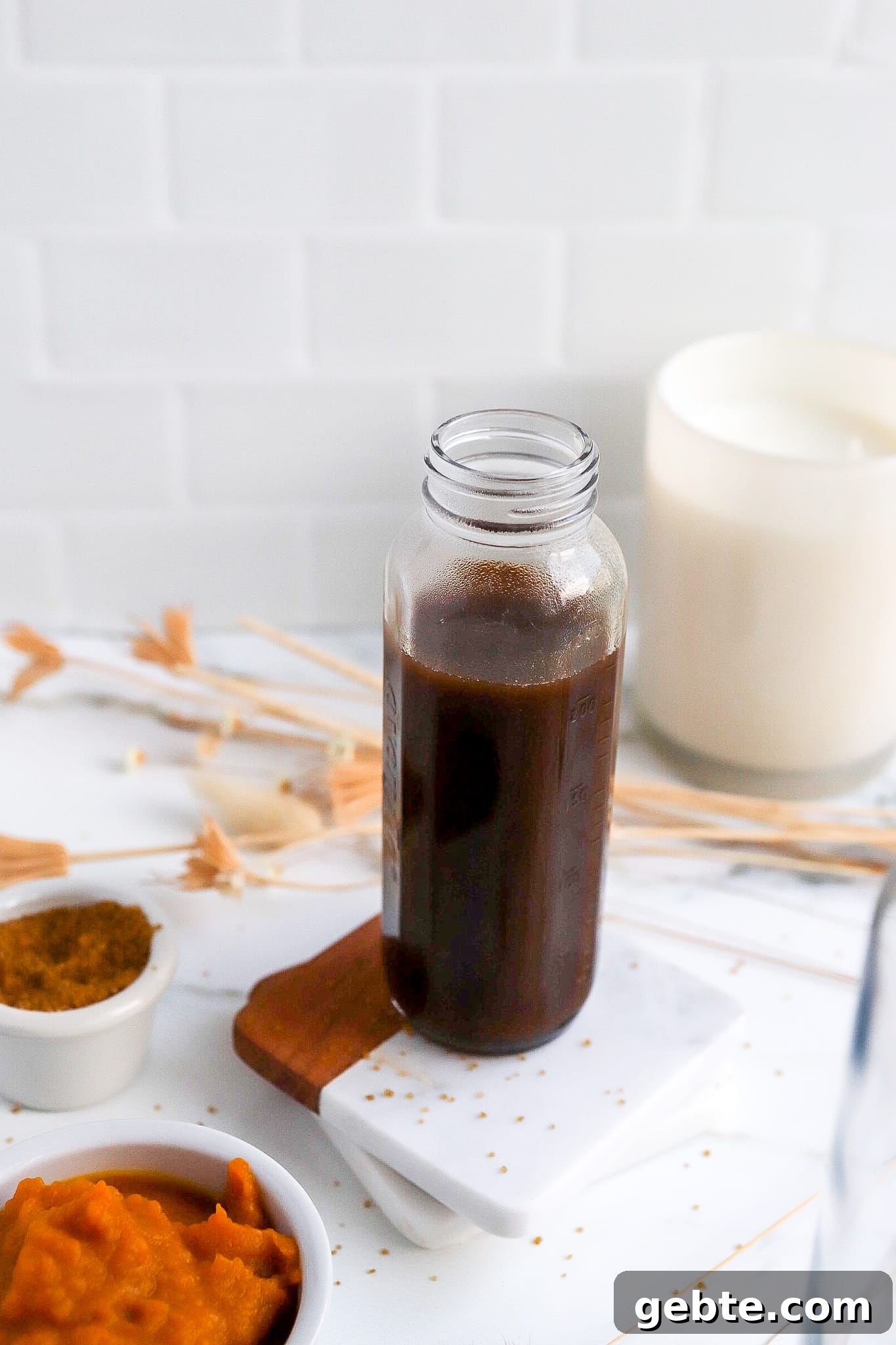delicious pumpkin spice syrup in a glass jar with pumpkin puree in foreground