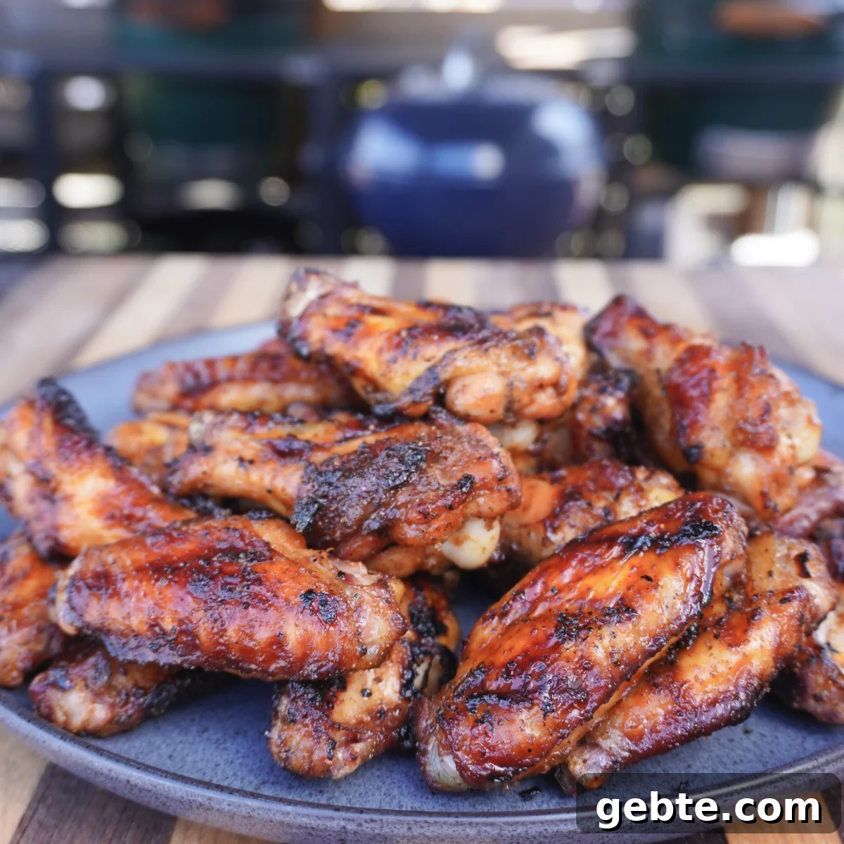a pile of grilled maple bourbon wings  on a plate.
