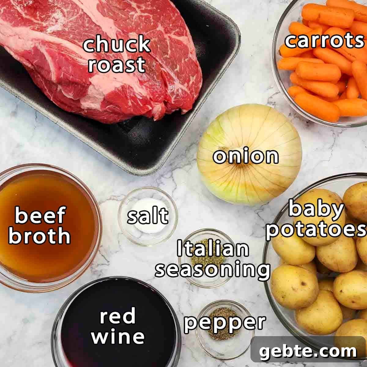 Overhead shot of ingredients - chuck roast, carrots, onion, baby potatoes, beef broth, red wine, salt, pepper, and italian seasoning.
