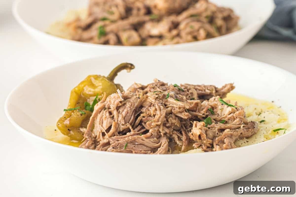 31 Slow Cooker Recipes to Walk In and Find Dinner Waiting 19 Mississippi Pork Roast garnish served over mashed potatoes in a white bowl.