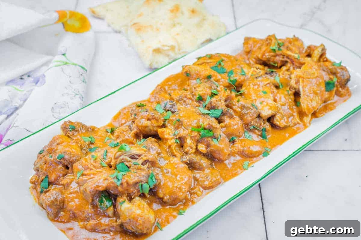 31 Slow Cooker Recipes to Walk In and Find Dinner Waiting 27 A rectangular plate of Chicken Tikka Masala with herbs on top.
