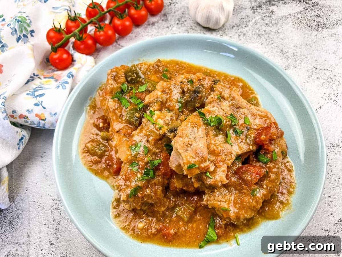 31 Slow Cooker Recipes to Walk In and Find Dinner Waiting 29 Slow Cooker Swiss Pork Chops on a baby blue serving dish.