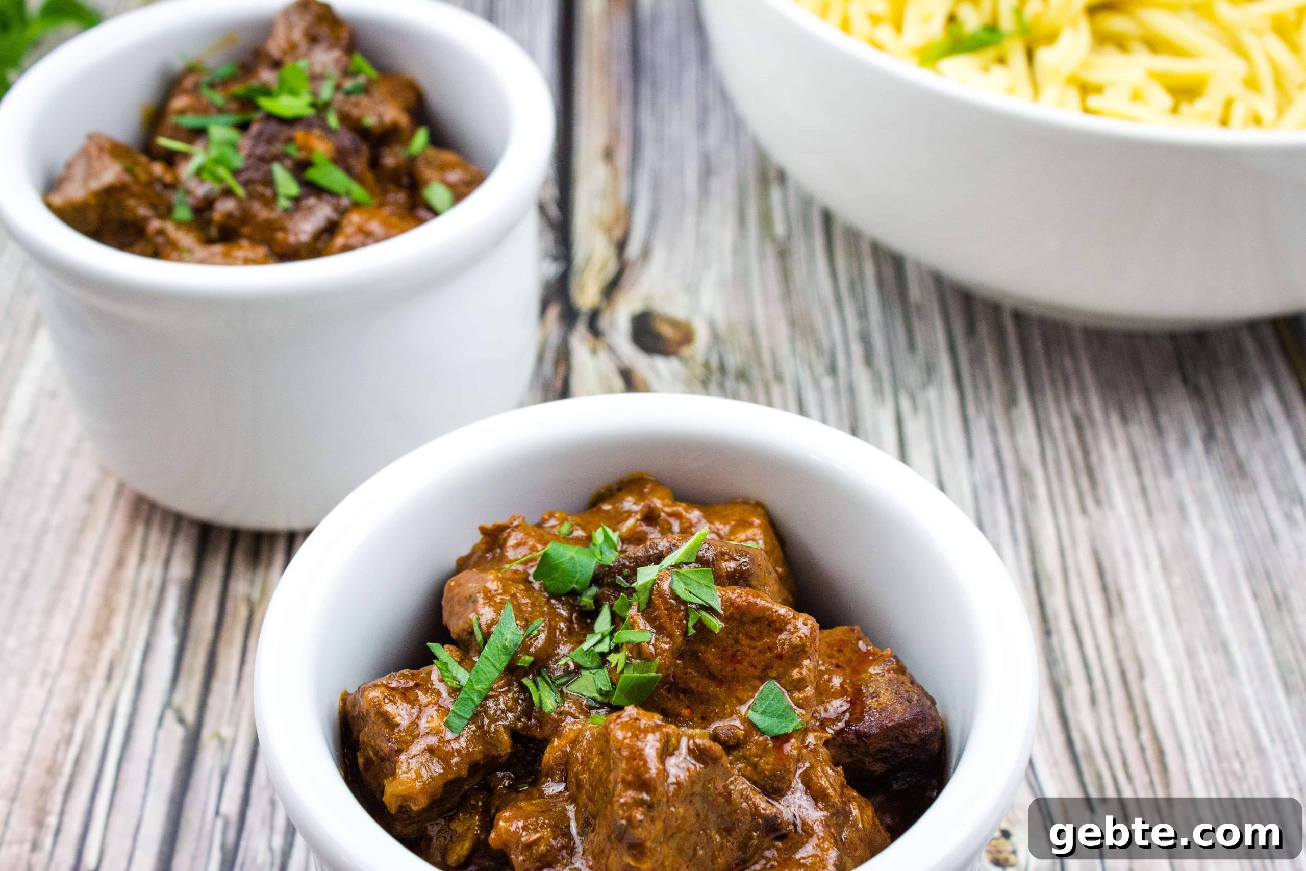 31 Slow Cooker Recipes to Walk In and Find Dinner Waiting 30 Hungarian Goulash in two white bowls.