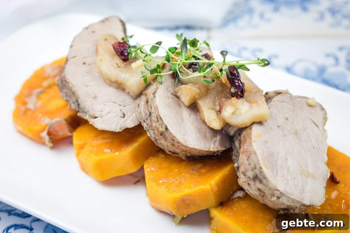 31 Slow Cooker Recipes to Walk In and Find Dinner Waiting 4 A serving of Slow Cooker Pork Tenderloin with Sweet Potatoes & Apples on a white platter.
