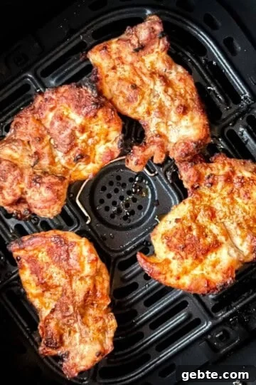 Perfectly cooked air fryer boneless thighs in the air fryer basket.