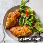 A closeup of chicken breasts on a plate with a salad.