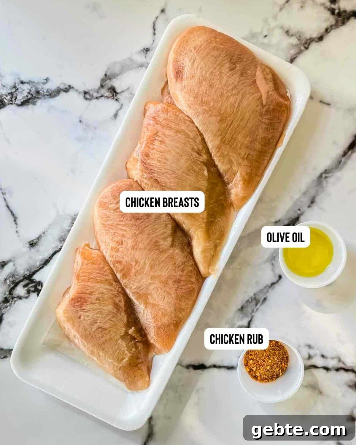 Ingredients for frozen chicken breasts in the air fryer on a white table.