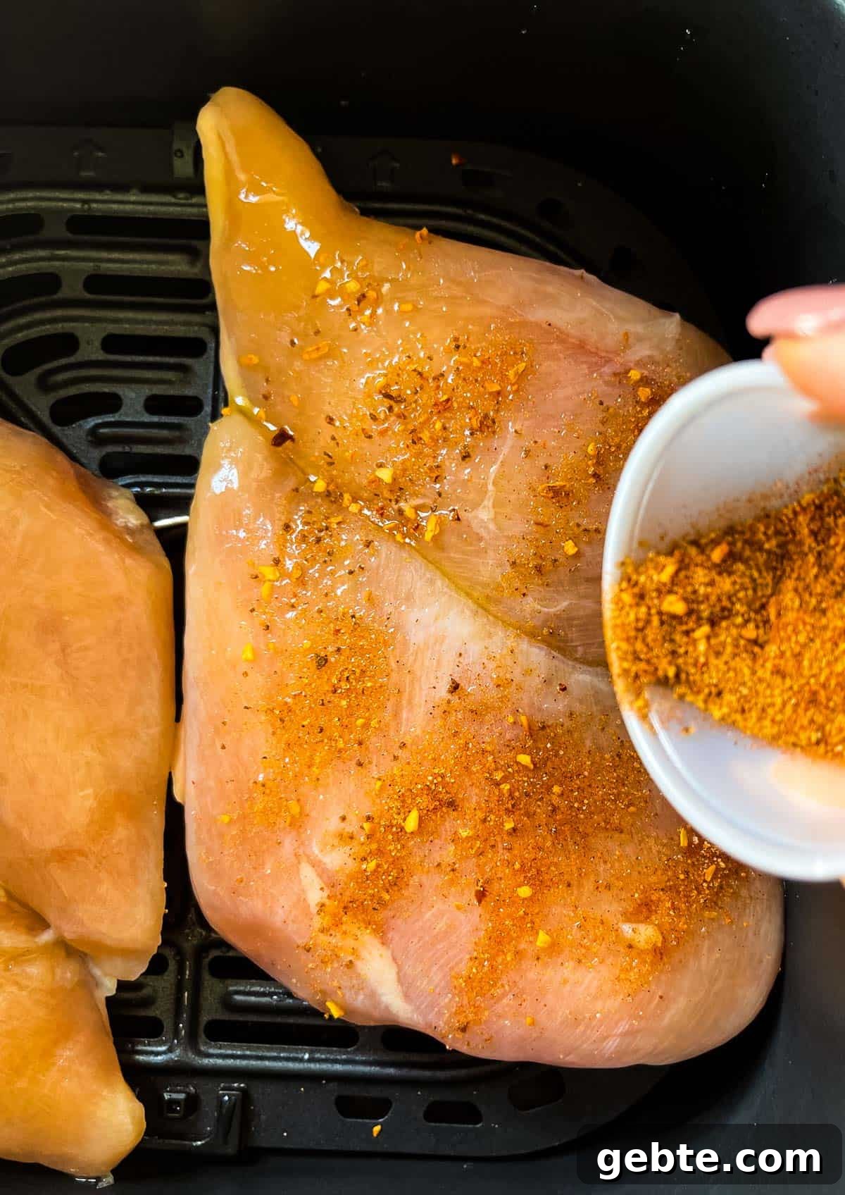Dry rub being sprinkled on top of the frozen chicken.