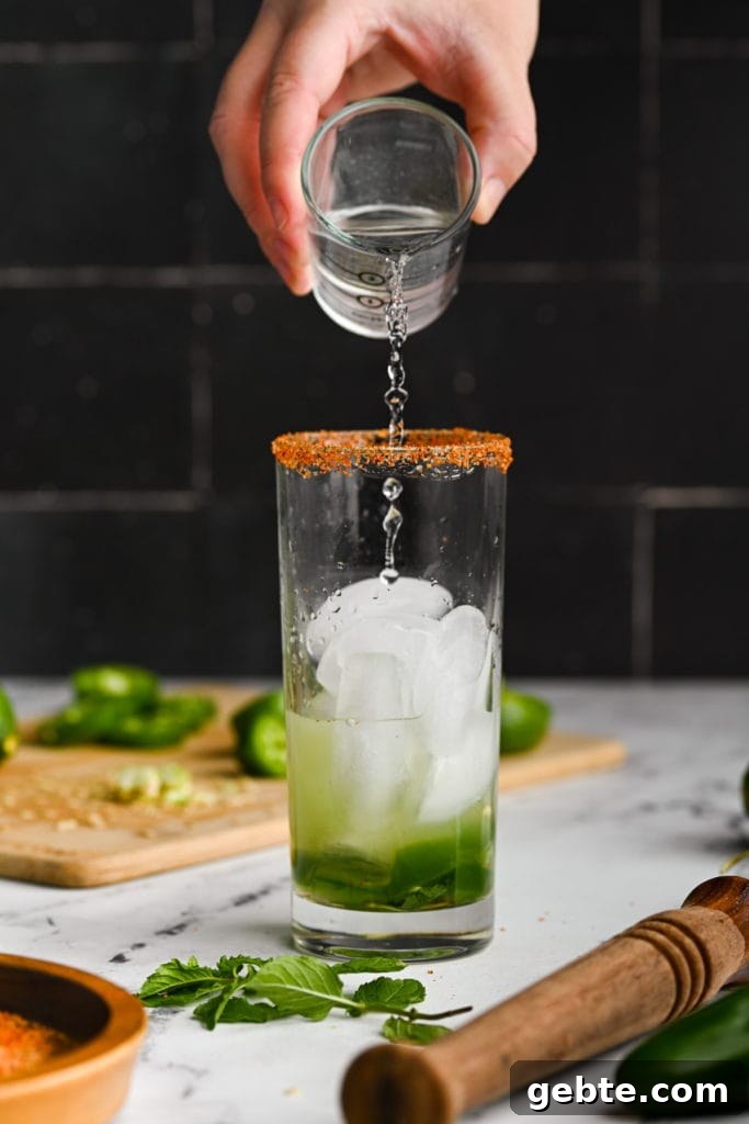 Adding white rum to a spicy mojito.