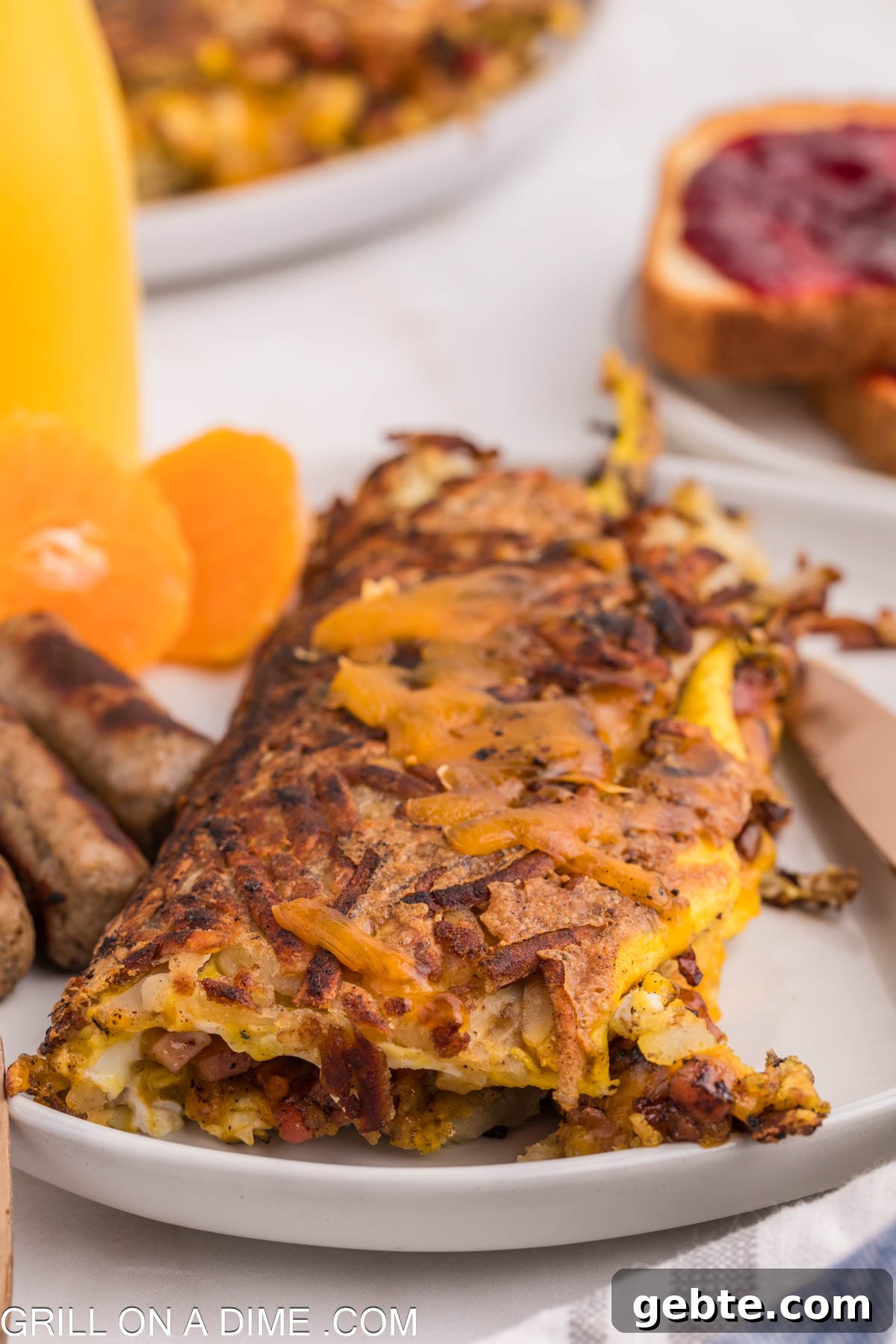 Hashbrown Omelette on a plate with breakfast sauce and slice oranges
