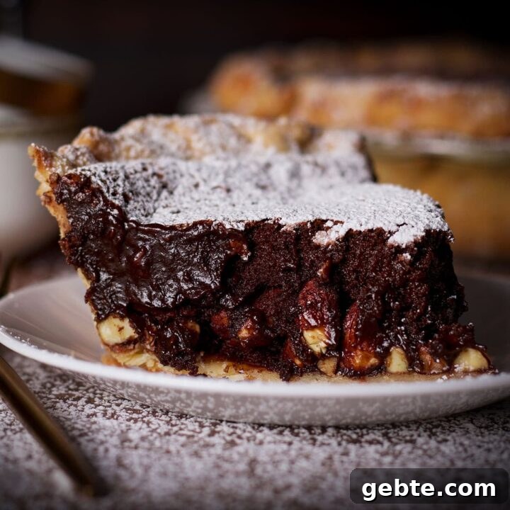 A slice of chocolate almond pie on a white plate.