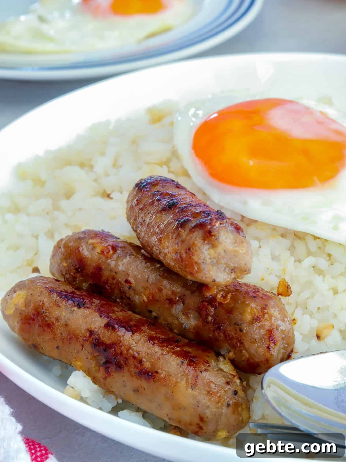 Homemade Skinless Longganisa Recipe: Filipino Sausage Without Casing 7 Skinless Longganisa on a serving plate with fried eggs and garlic fried rice