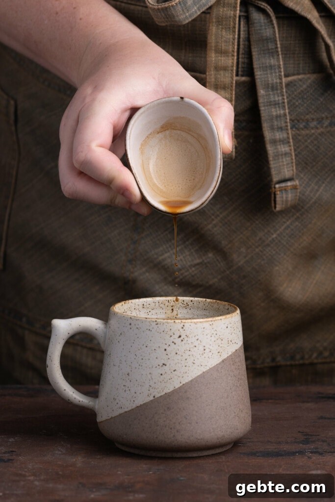 Adding vanilla extract to mug with mashed banana.