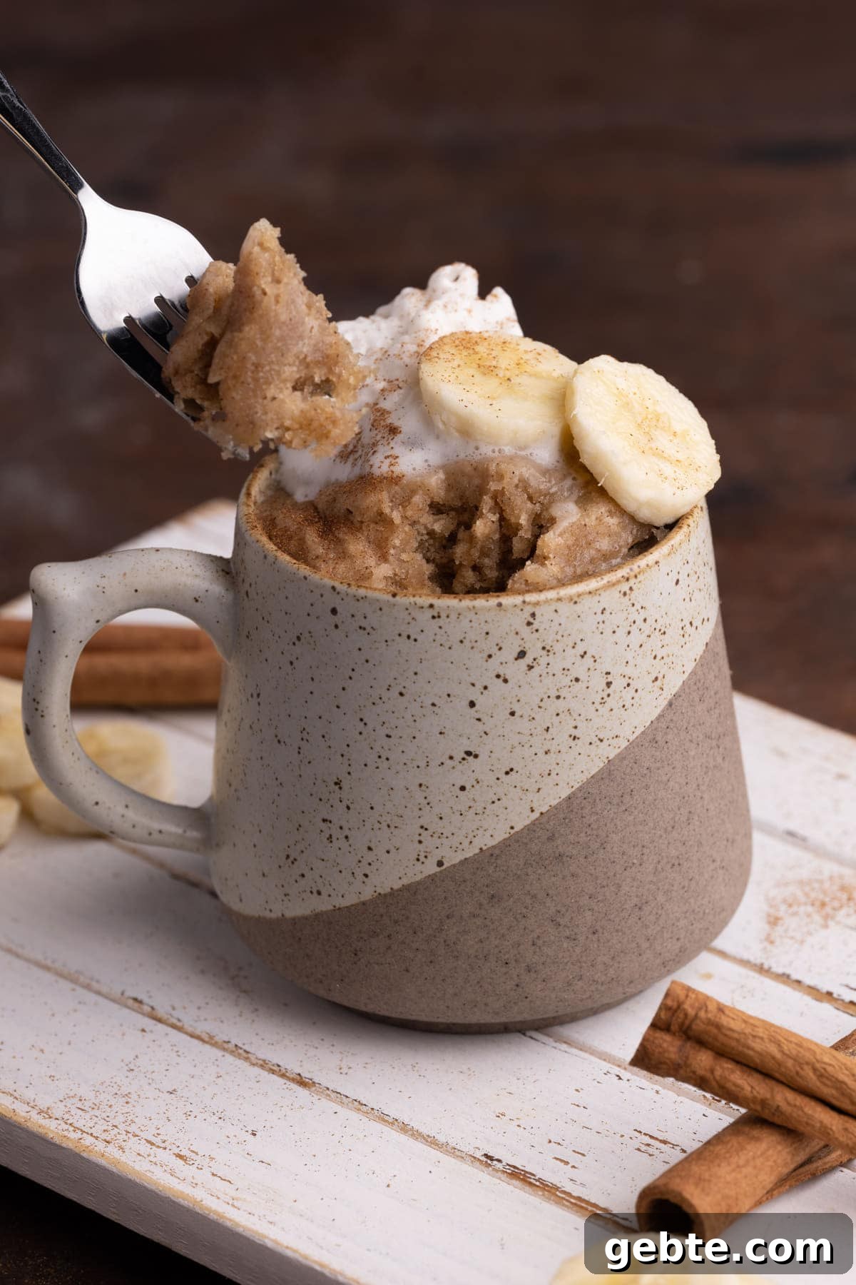 Grabbing a forkful of banana bread in a mug