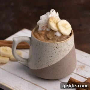 Banana Bread in a Mug topped with sliced banana and whipped cream