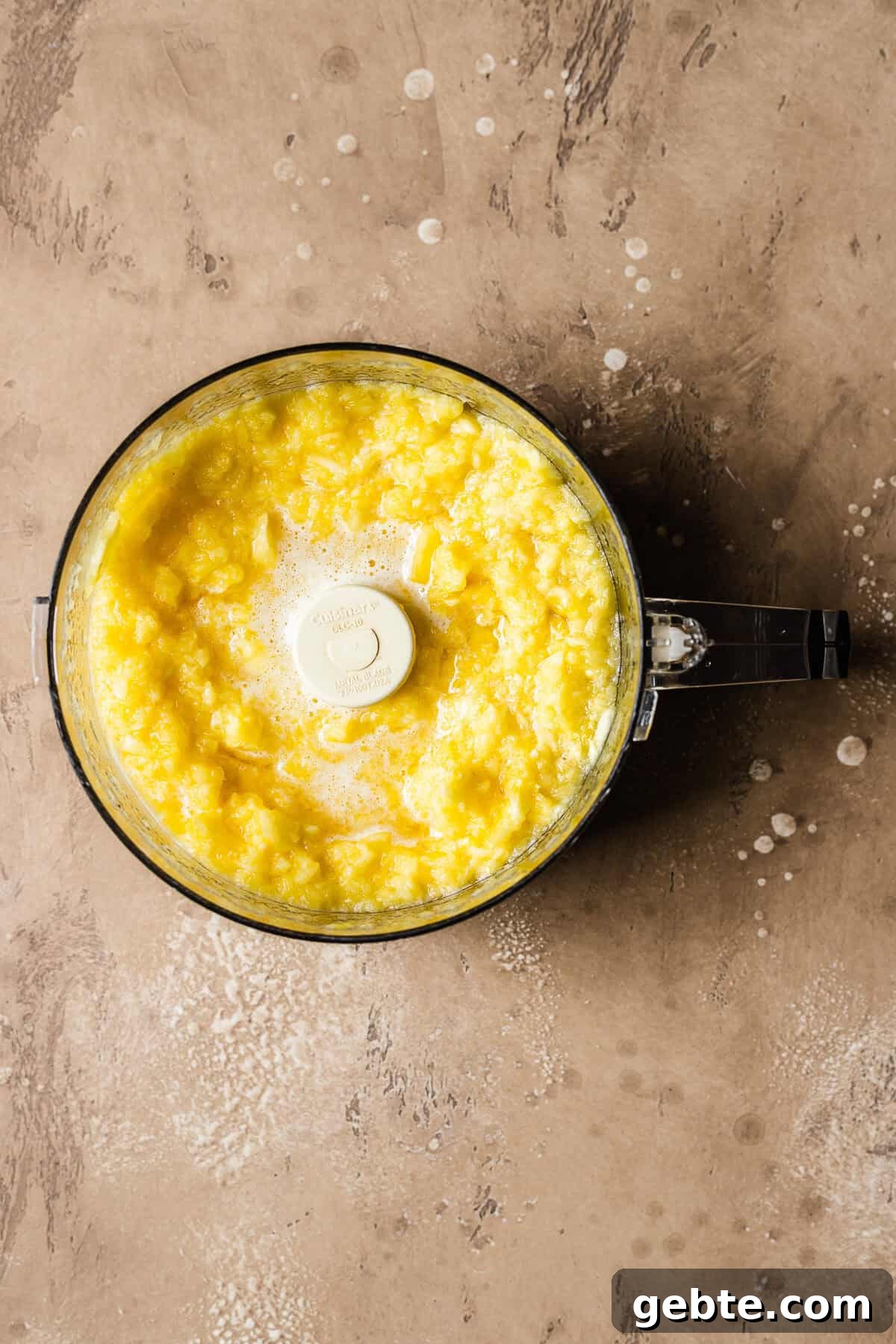 Fresh pineapple pureed in a food processor.