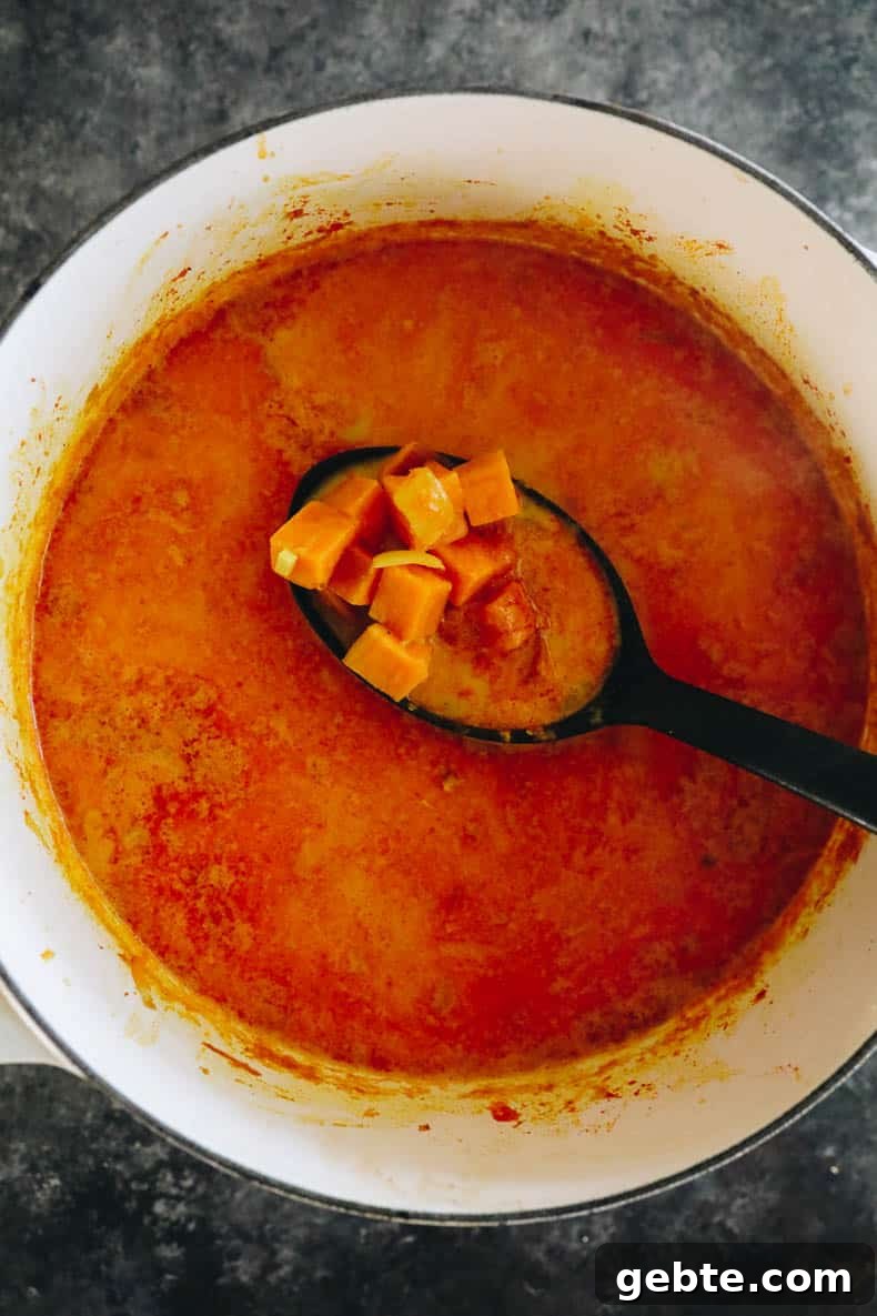 Creamy Curried Sweet Potato Soup Recipe for Cozy Dinners 4 Cooked sweet potato soup in a white dutch oven.