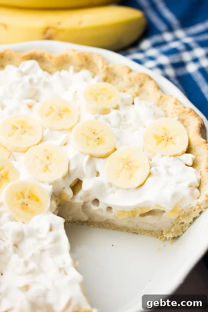 piece of banana cream pie cut out, bananas in back