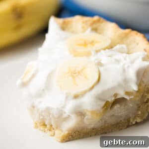square image of creamy pie with bananas and bite taken out of it