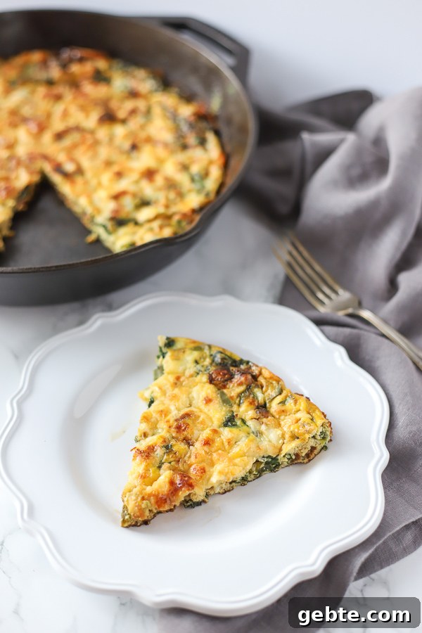 spinach frittata on a white plate with a fork