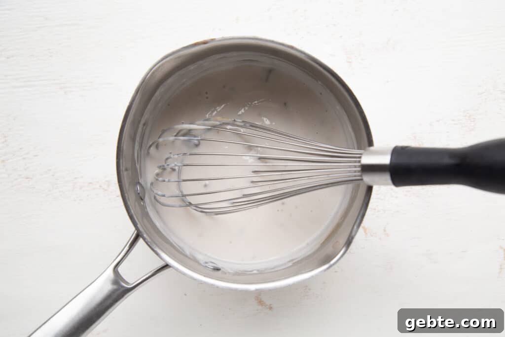 condensed soup and a whisk in a saucepan.