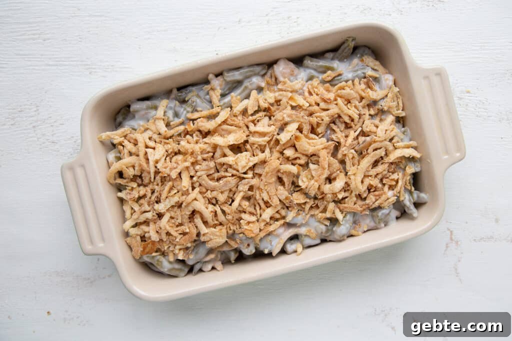 unbaked green bean casserole topped with french fried onions.